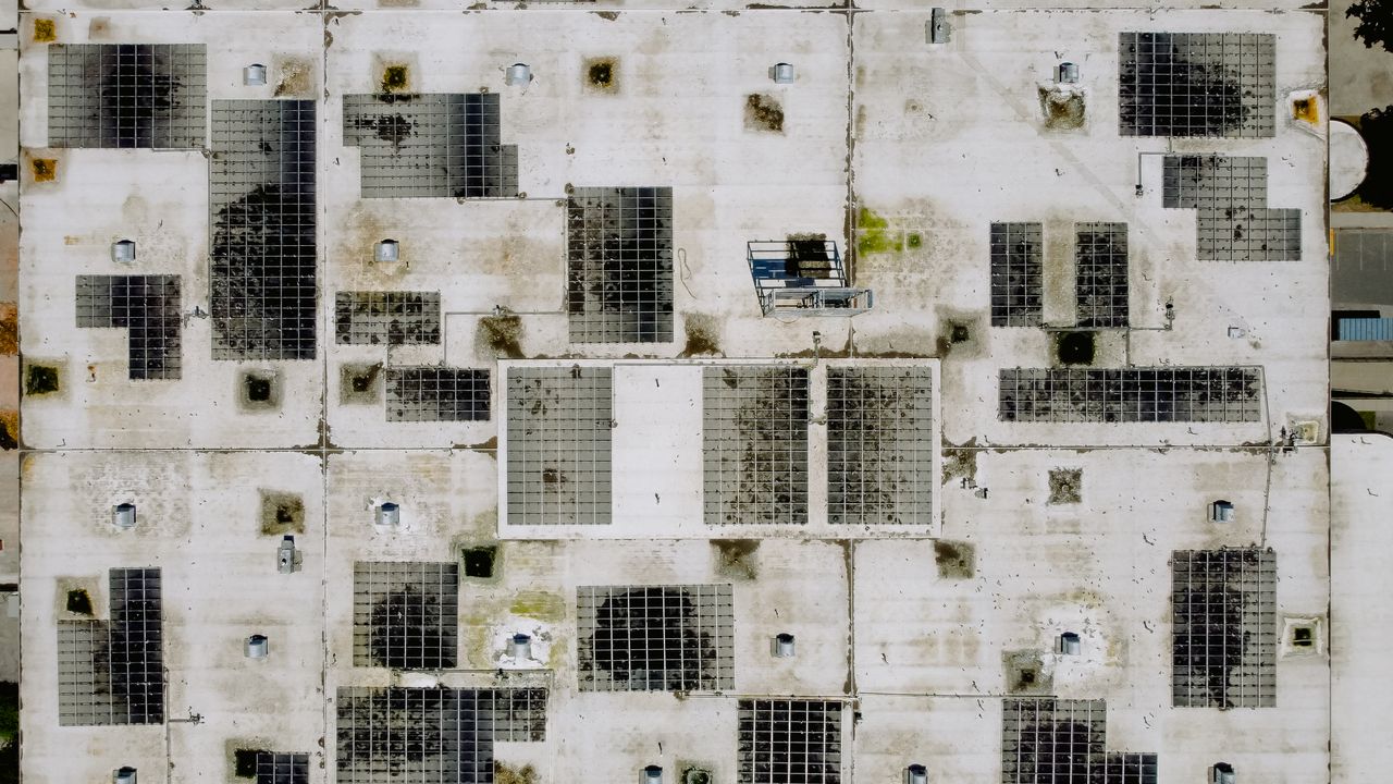 About An industrial rooftop with solar panels, viewed from above, ideal for renewable energy concepts.